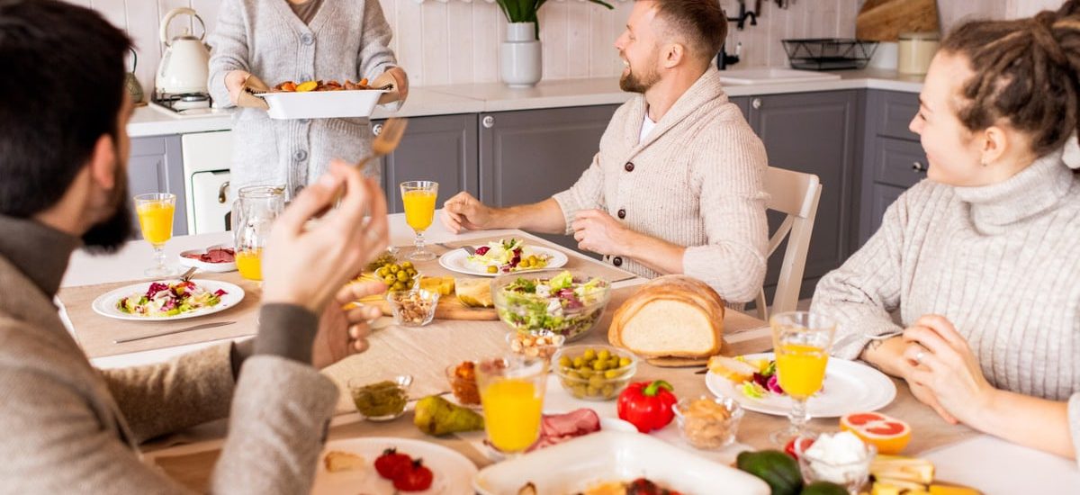 Group of friends enjoying a vibrant meal indoors, sharing laughter and good food.